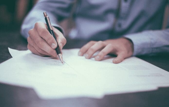 A man signing documents to recast his mortgage